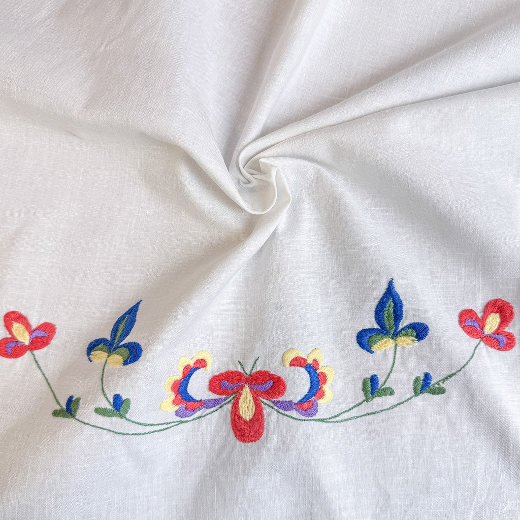 Fint stykke med to broderier og bølgekant